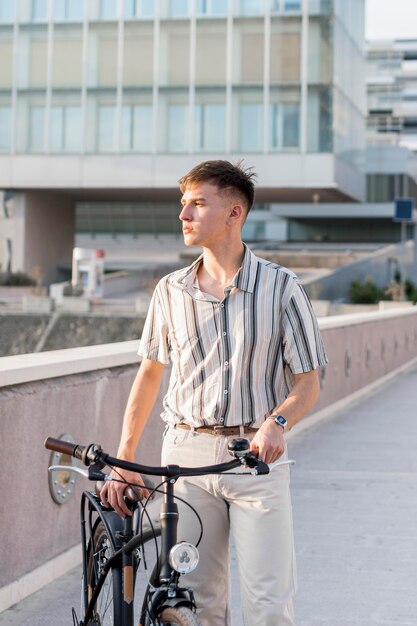 Vista frontale dell'uomo all'aperto con la bicicletta