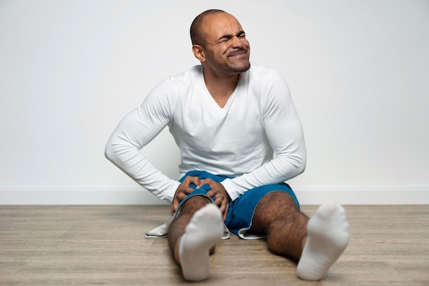 Free photo front view of man at physiotherapy with knee pain