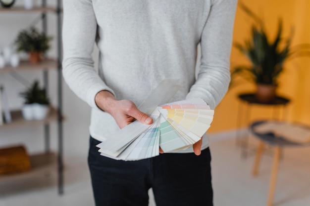 Front view of man planning to redecorate the house using paint palette