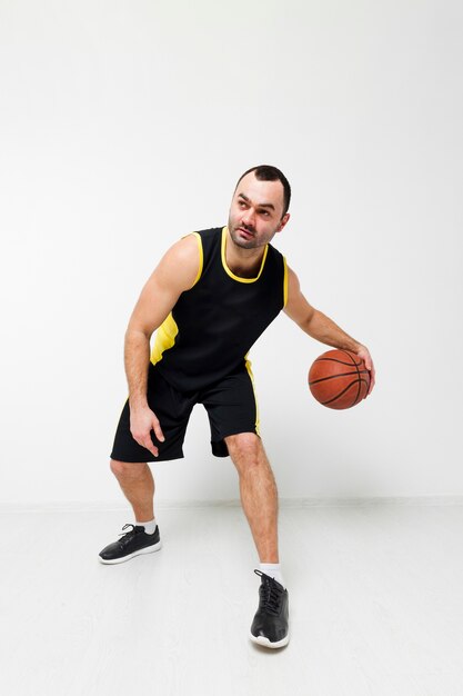 Front view of man playing basketball in sneakers