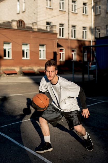 Free photo front view man playing basketball