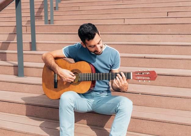 Front view of man playing the guitar