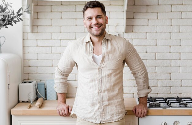 Front view man posing in kitchen