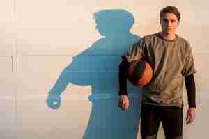 Free photo front view man posing with a basketball