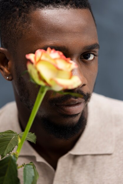 美しい花でポーズをとる正面図の男