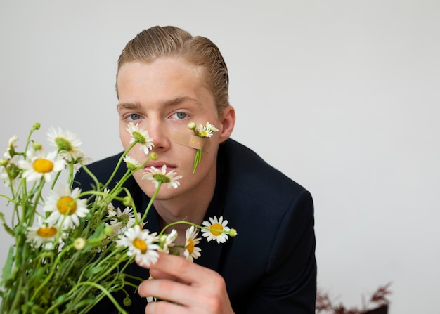Foto gratuita uomo di vista frontale che posa con i bei fiori