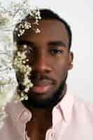 Foto gratuita uomo di vista frontale che posa con i fiori