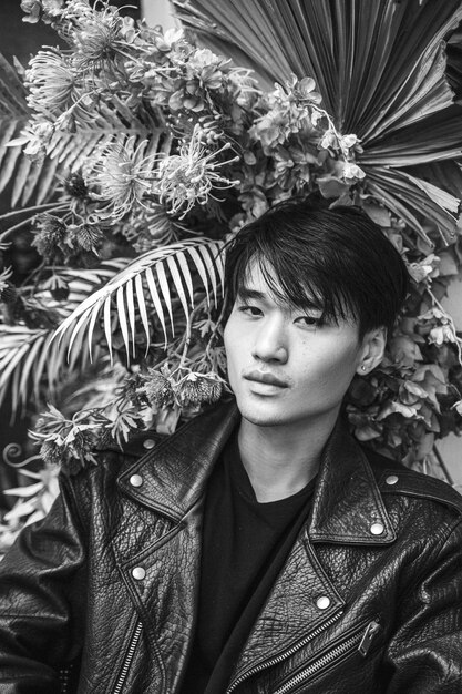 Front view man posing with plants black and white