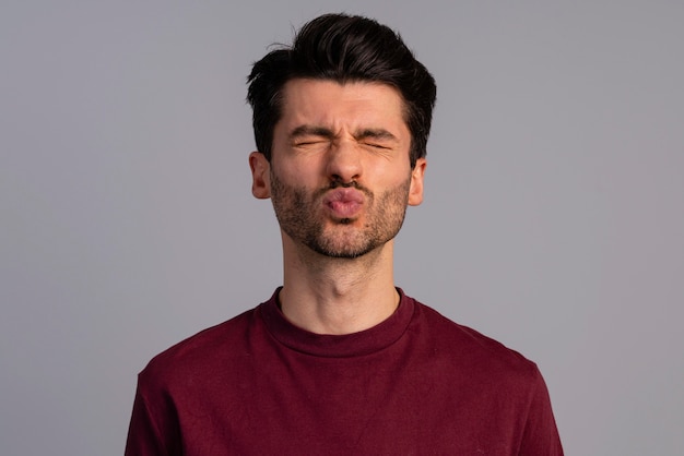 Front view of man pouting lips for a kiss