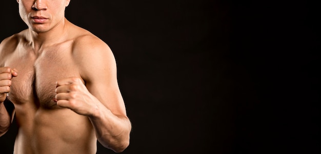 Front view of man practicing boxing stance with copy space