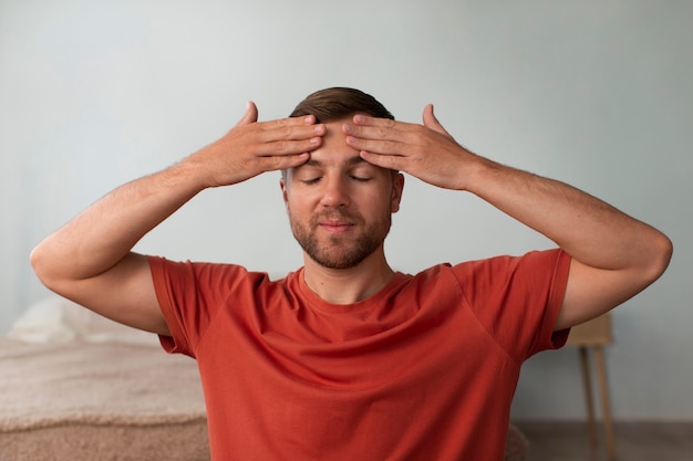 Foto gratuita uomo di vista frontale che pratica yoga facciale