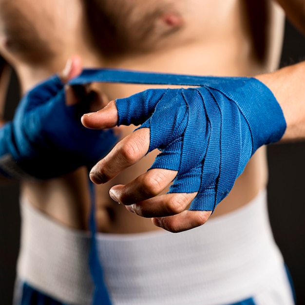 Front view of man putting on protection for hands