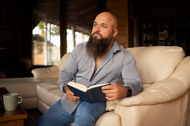 Бесплатное фото Вид спереди мужчина читает дома