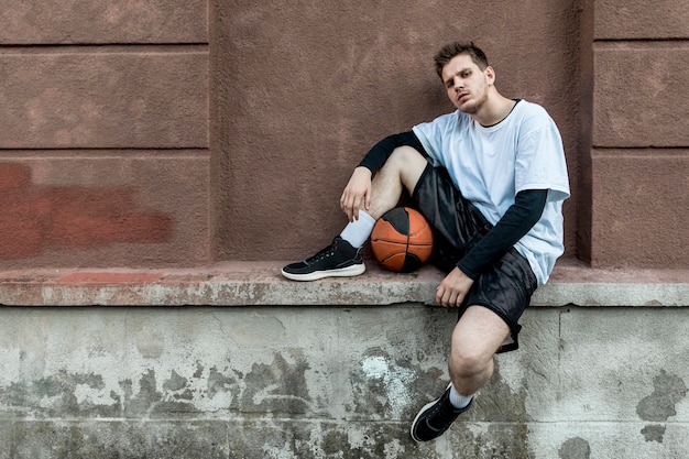 Free photo front view man relaxing with a basketball