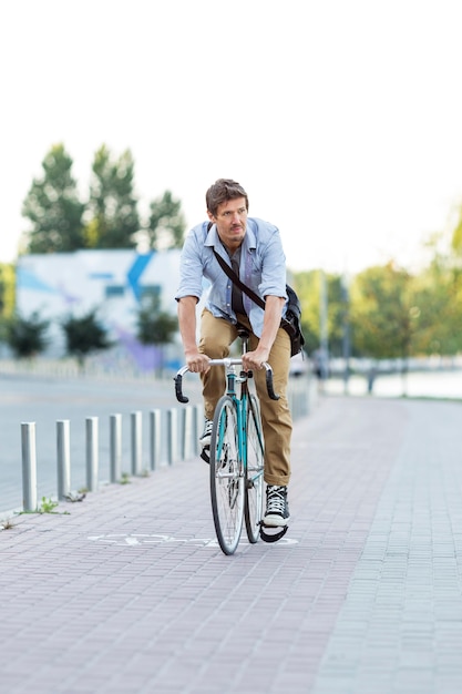 Foto gratuita uomo di vista frontale che guida la bicicletta all'aperto