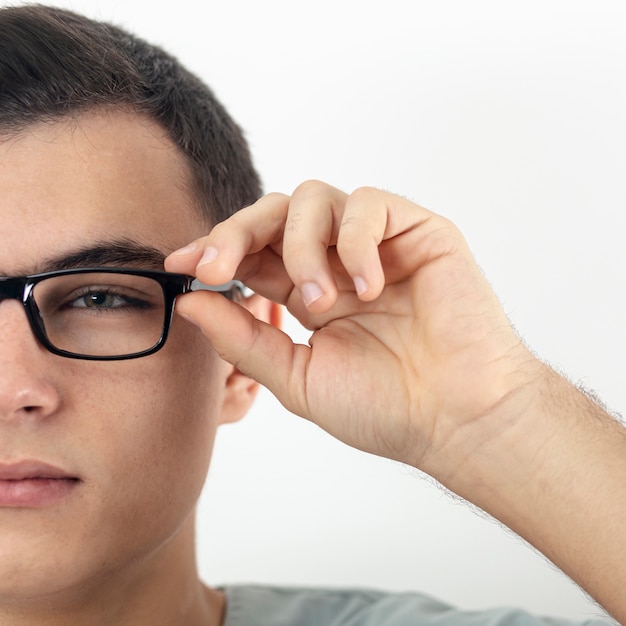 Front view of man's half face putting on glasses
