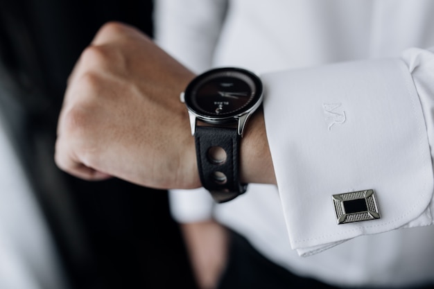 Front view of man's hand with stylish watch and sleeve