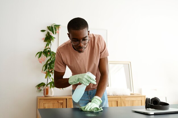 Front view man servant cleaning table