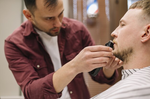 Front view of man shaving his beard
