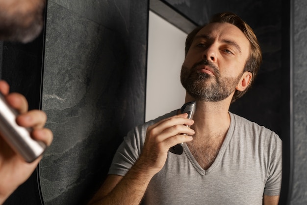 Front view man shaving at home