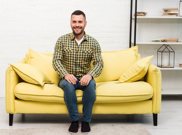 Free photo front view of man sitting on couch
