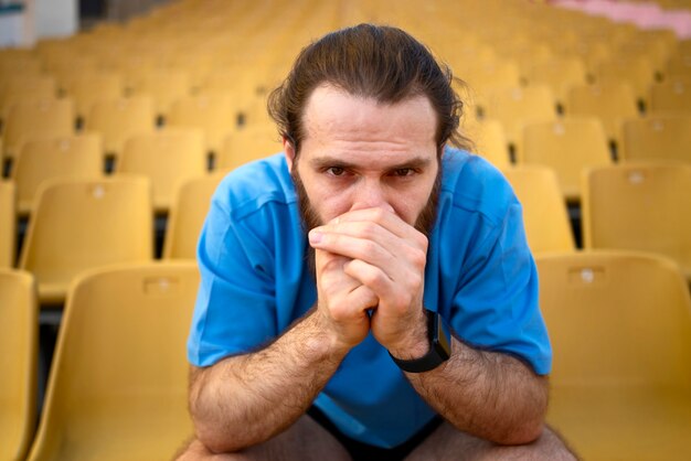 Front view man sitting on grandstands