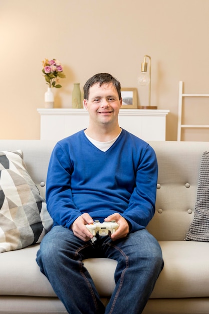 Free photo front view of man on sofa at home playing video games