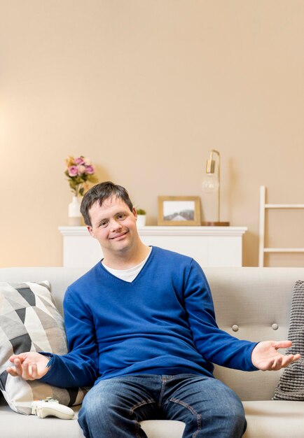 Front view of man on sofa at home with copy space