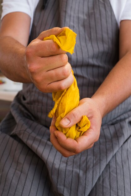 Front view man squeezing cloth from natural pigment