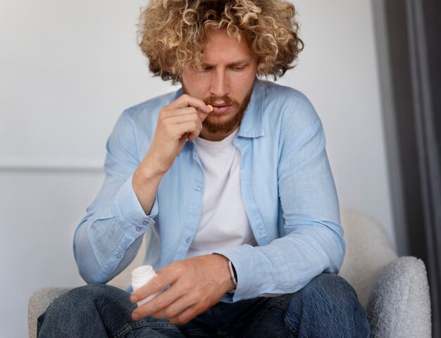 Front view man taking anxiety pill