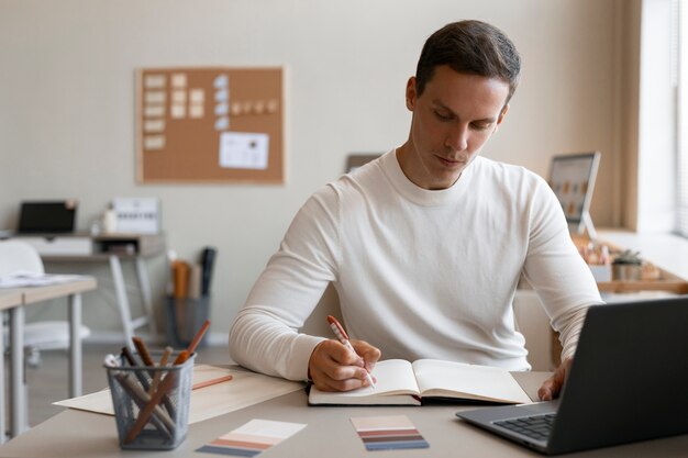 Front view man taking notes at office