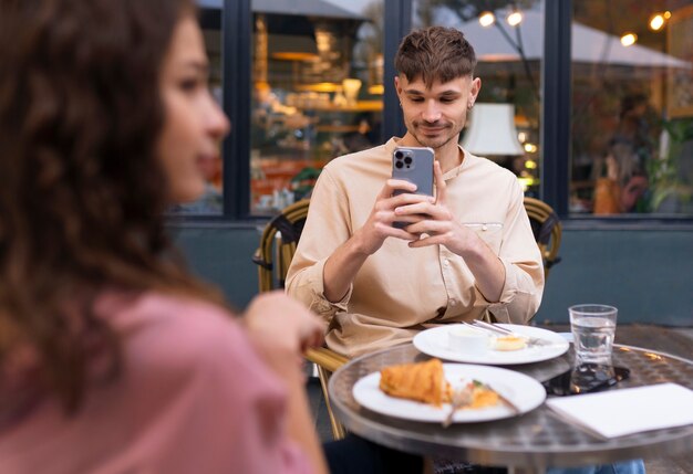 front view man taking photos with smartphone