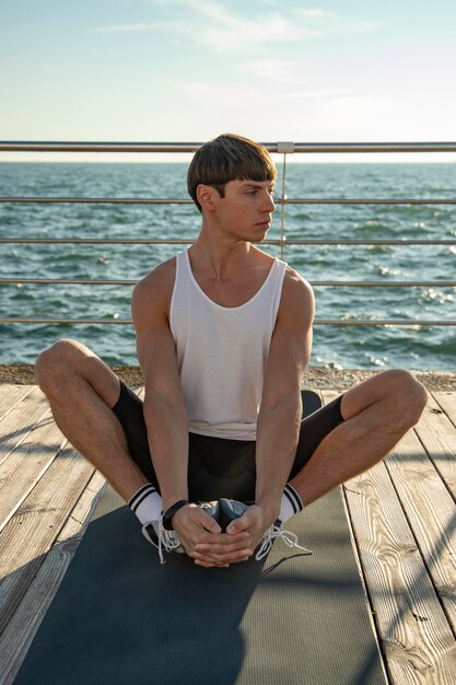 Front view of man in tank top working out at the beach