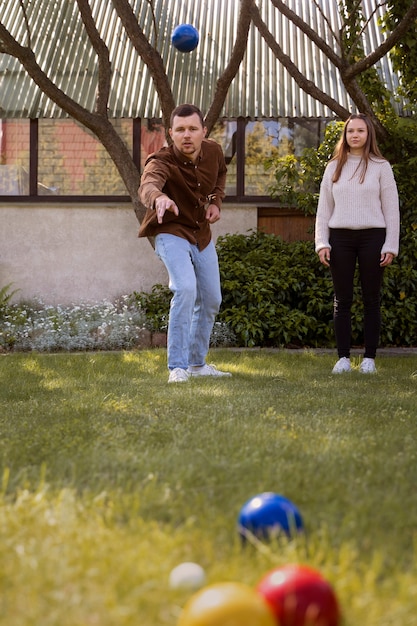 Free photo front view man throwing blue ball