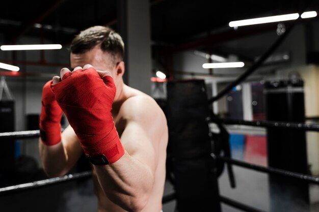 Вид спереди человек тренируется в боксерском ринге