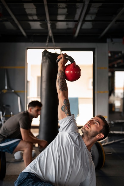 Free photo front view man training with kettlebell