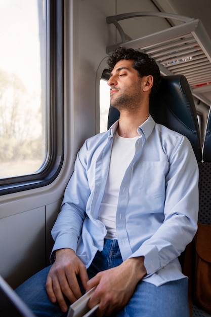 Free photo front view man traveling by train