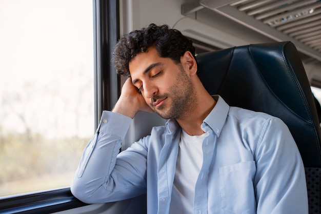 Free photo front view man traveling by train