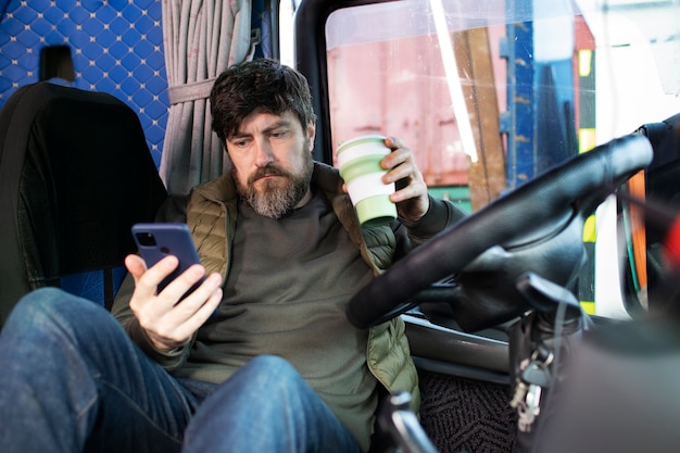 Front view man in truck with drink