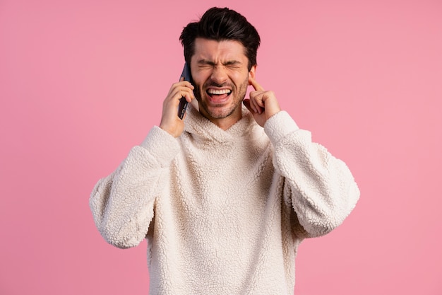 Front view of man trying to hear while on a phone call