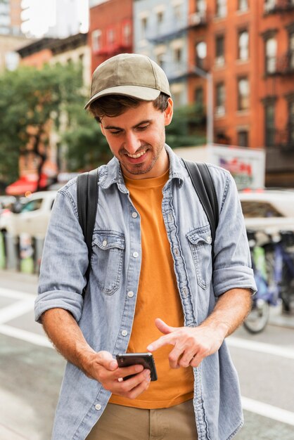 Front view man using mobile in city