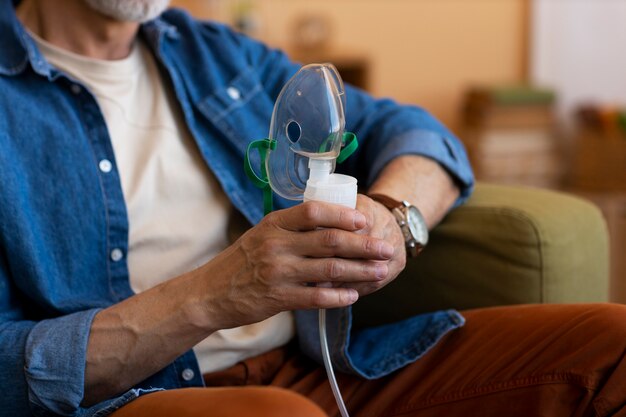 Front view man using nebulizer