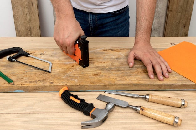 Foto gratuita uomo di vista frontale utilizzando uno strumento di pistola su legno