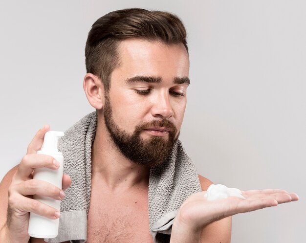 Вид спереди человек, использующий крем для бритья