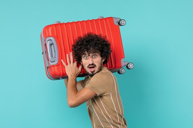 Front view man in vacation holding his big bag on blue