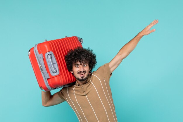 Front view man in vacation holding his big bag on blue