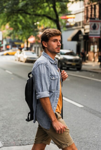 Front view man with backpack in city