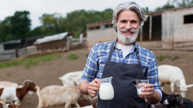 Foto gratuita uomo di vista frontale con una bottiglia di latte di capra
