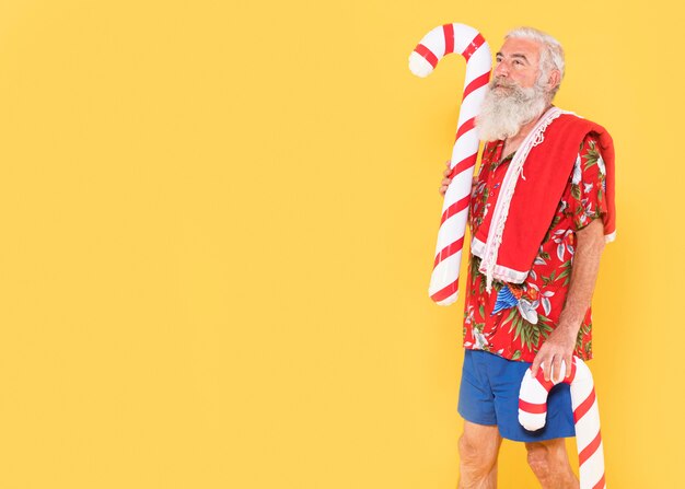 Front view of man with candy cane and copy space