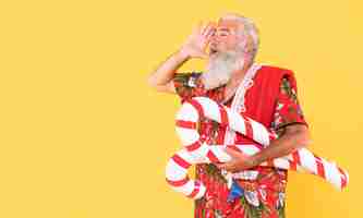 Free photo front view of man with candy cane and copy space